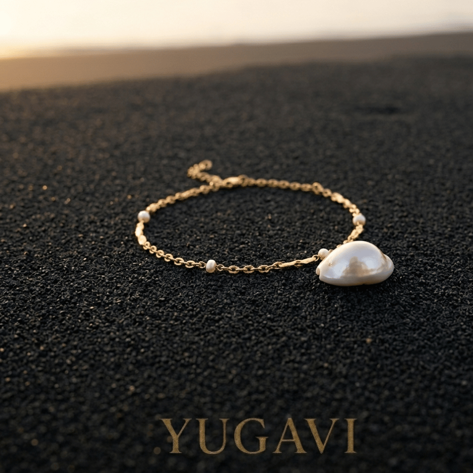 Gold anklet and shell on black sand — Yugavi Sun Sand and Gold collection