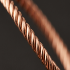 A close-up of a twisted copper-colored wire or cable against a dark gray background.