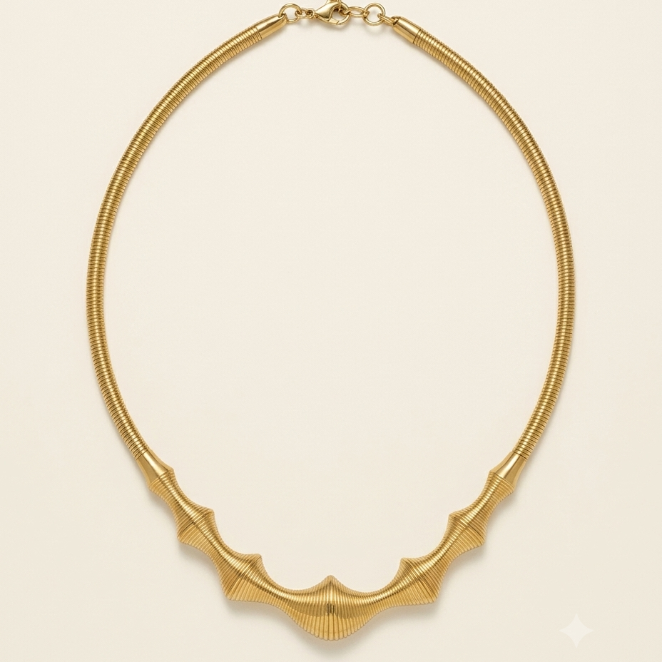 A gold snake chain necklace with a textured, ribbed bat-wing or wing-like centerpiece, displayed on a clean, solid cream background.