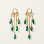 A pair of gold dangle earrings with five green teardrop gemstones and small clear crystal accents, displayed on a clean off-white background.