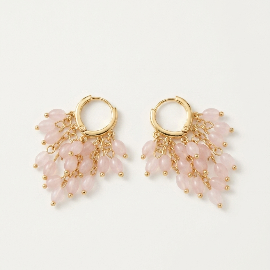 A pair of gold hoop earrings with cascading dangles of pale pink teardrop beads and small gold beads, displayed on a clean off-white background.