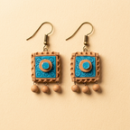 A pair of handmade dangle earrings with square turquoise and terracotta charms, suspended from gold-tone fishhook wires with small bead drops, set against a solid beige background.