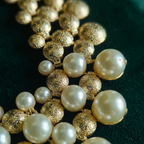 Close-up of Muktāvali matte gold dome and ivory faux pearl cascading statement necklace — Boho jewellery by House of Yugavi