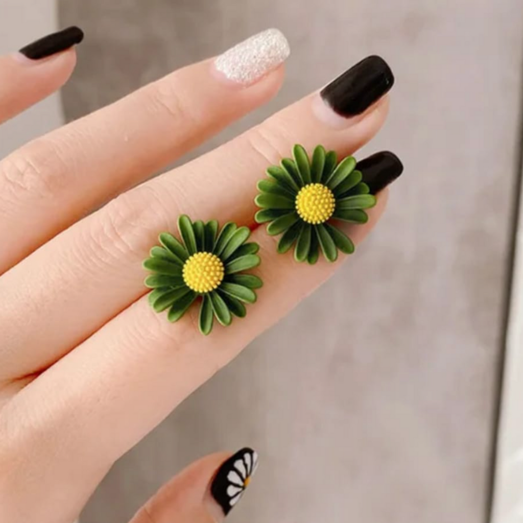 Close-up of Yugavi Kavya earring centre — raised textured dome of individual yellow pollen spheres surrounded by ribbed forest green daisy petals, matte enamel-effect finish on dark green flower stud earring