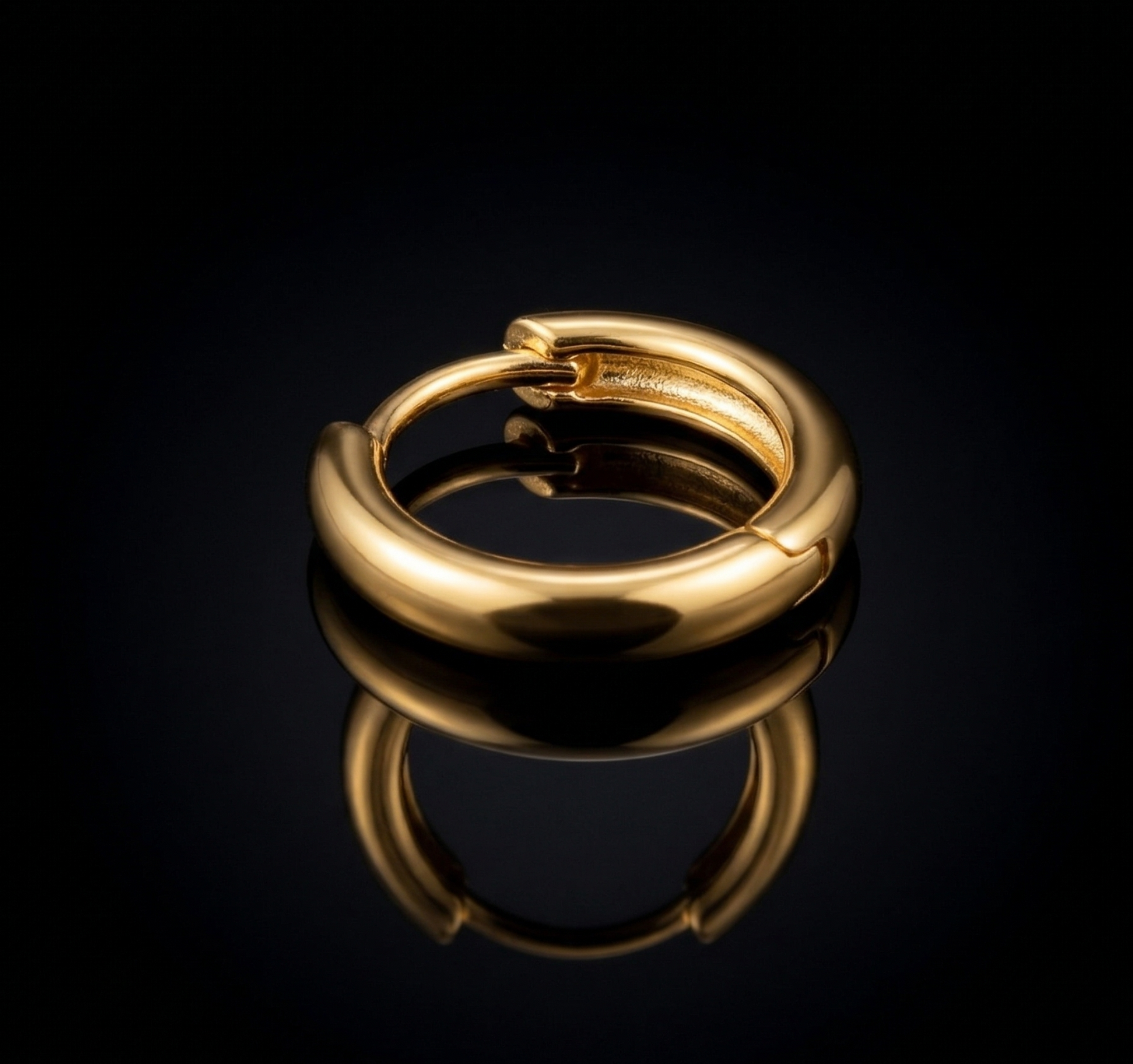 Close-up of Yugavi Mandala Hoops — smooth tubular high-polish 22K gold hoop with precision click snap closure detail