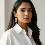 Close-up of Yugavi Oorja earring interior — three vertically stacked solid gold butterfly silhouettes with wings spread symmetrically, set against a darker recessed background inside a pavé CZ crystal rectangular gold border