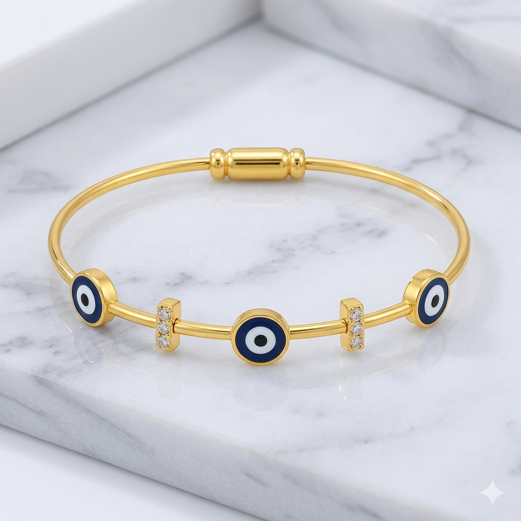 Gold bracelet with blue evil eye charms on a marble surface