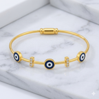 Gold bracelet with blue evil eye charms on a marble surface