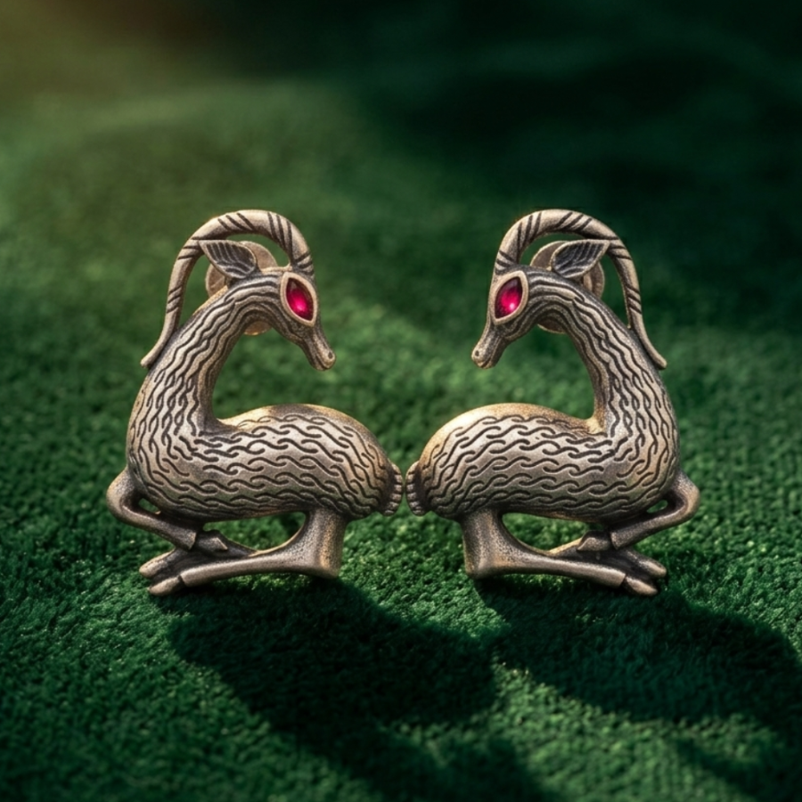 Pair of dragon-shaped earrings on a green textured surface