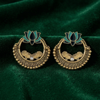 Close-up of Yugavi Sadira teal enamel lotus crown — two-tone stylised lotus with teal outer petals and deep forest green inner petals in flat graphic meenakari enamel, rising from the top of the antique gold open circle earring