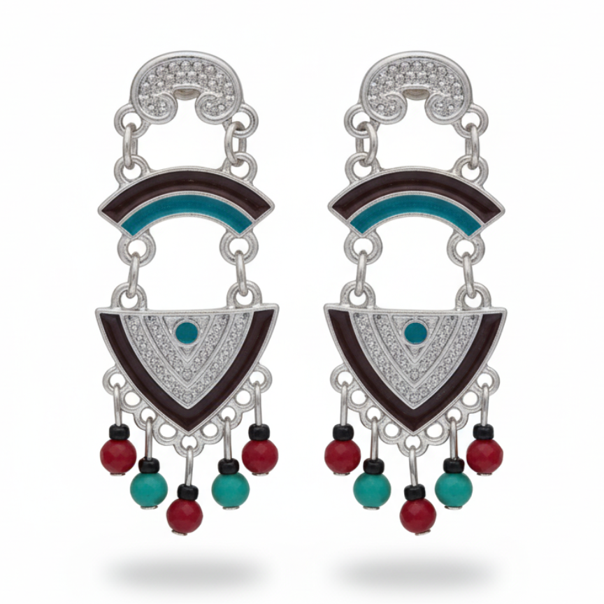 Close-up of silver earrings with turquoise detail and red beads