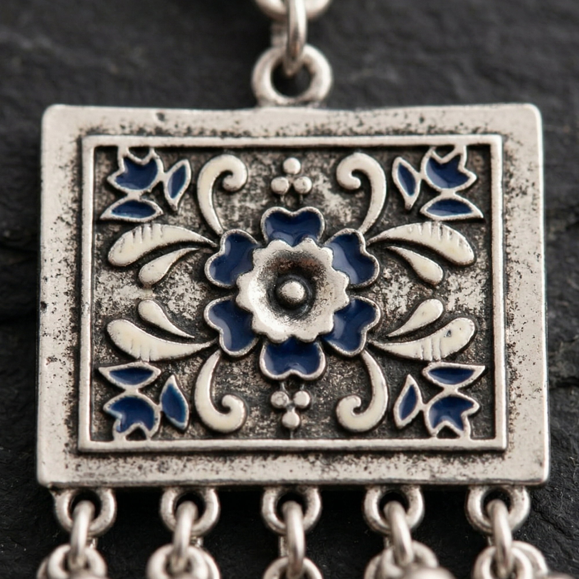 Detail of Yugavi Arita starburst disc stud — round oxidised silver disc with radiating geometric starburst mandala engraving from a central polished dome, push-back stud closure, deep oxidised finish