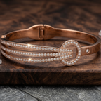 Detail of Yugavi Ishvini triple pavé rails — three parallel channels of dense continuous white CZ crystals running across the rose gold bangle front face, separated by smooth rose gold rails, catching directional light along their full length