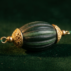 Detail of Yugavi Neelopa three-strand cascade — the three forest green cord strands at graduated lengths showing the layered necklace effect, grey chips and emerald crystal rondelles alternating along each strand, the layered cascade creating depth at the neckline