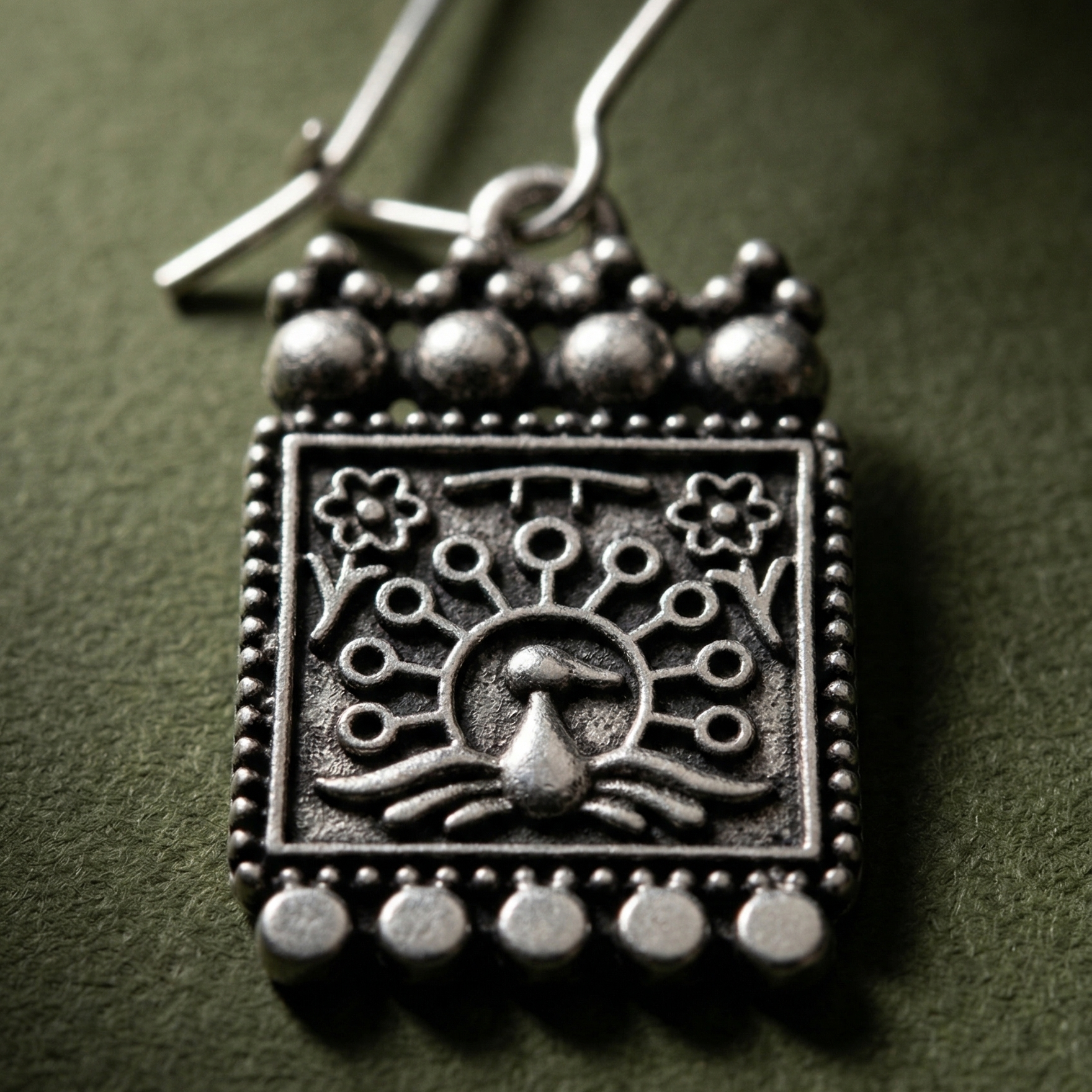 Detail of Yugavi Raksha tablet crown — five graduated oxidised silver balls with open filigree lace between them at the top edge, and five smaller silver ball drops along the base fringe, dot-bead border visible on all edges