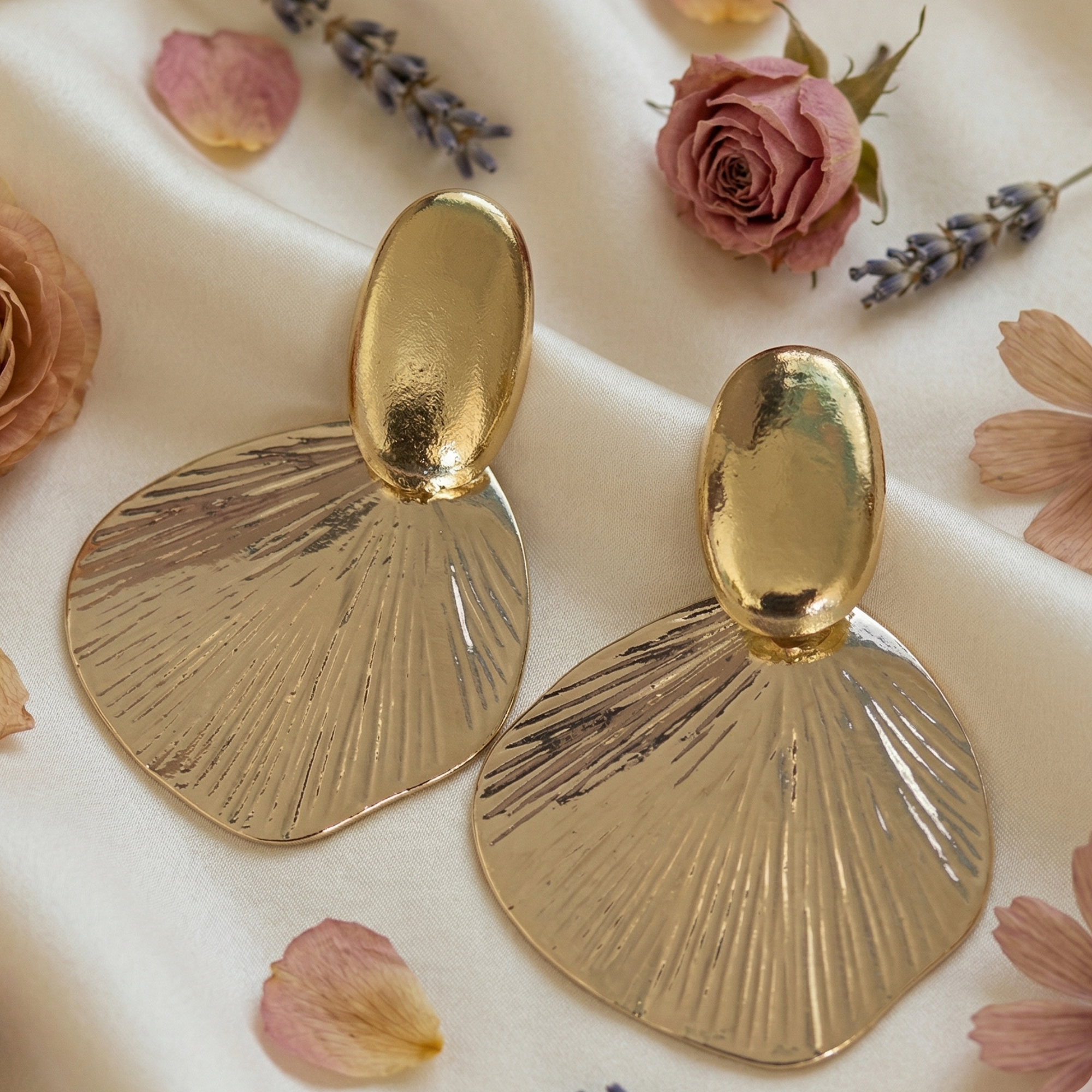 Earrings flat lay — gold sculptural oval stud and etched fan disc drop — Yugavi Surya Edit — houseofyugavi.com