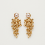 A pair of gold-toned statement dangle earrings featuring a round pearl at the top and cascading clusters of small gold beads below, displayed on a clean off-white background.