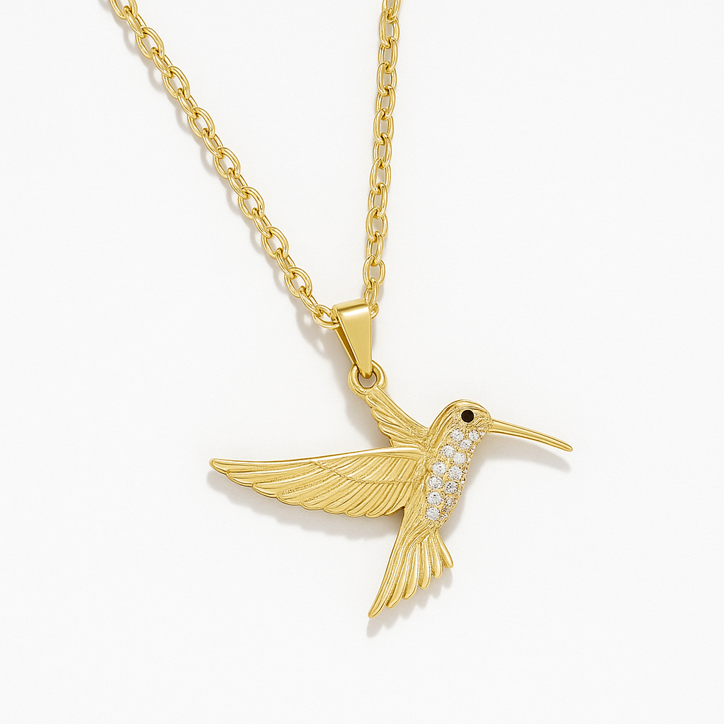 Macro detail of Yugavi Tara pendant wing — individual feather lines etched in fine gold relief across the hummingbird's spread wings, showing the texture and craft of the gold bird pendant necklace