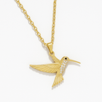 Macro detail of Yugavi Tara pendant wing — individual feather lines etched in fine gold relief across the hummingbird's spread wings, showing the texture and craft of the gold bird pendant necklace