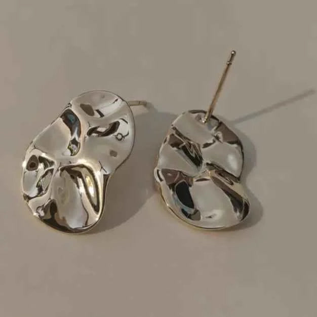Silver earrings on a light gray background