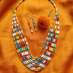 Varnāvali multicolour enamel ladder-link necklace and earring set in gold tone by House of Yugavi Kansyam, flat lay on green velvet