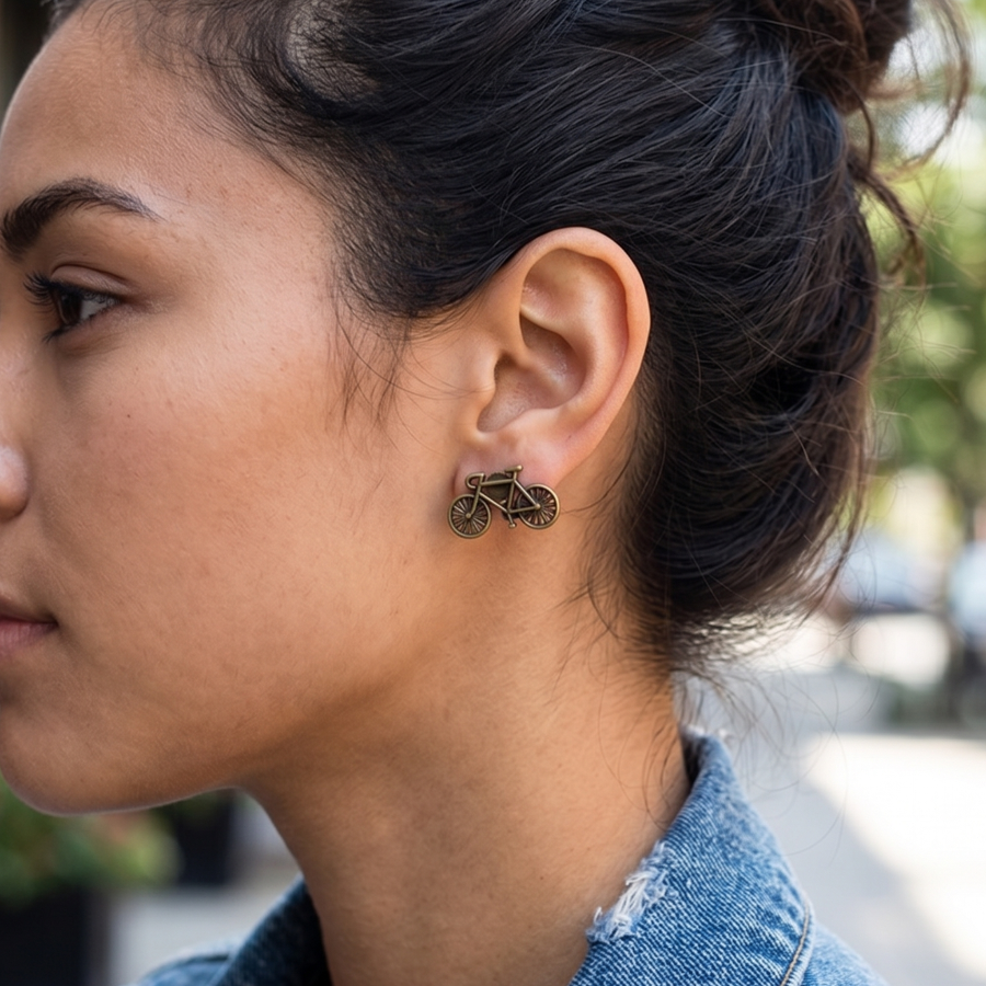 Woman wearing bicycle-shaped earrings with a blurred street background