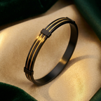 Black and gold bracelet on a beige fabric background