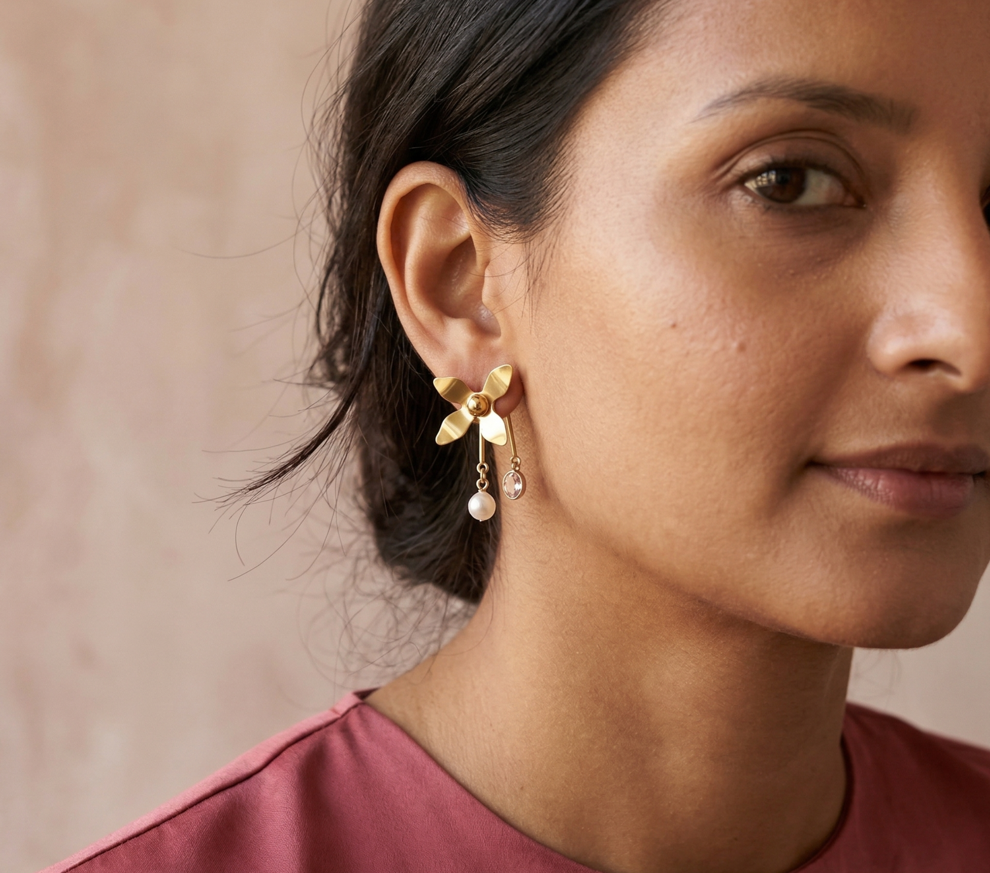 Yugavi Kanika gold floral drop earrings with pink CZ and pearl drop worn on ear — Yugavi Bloom Collection — Yugavi Jewels