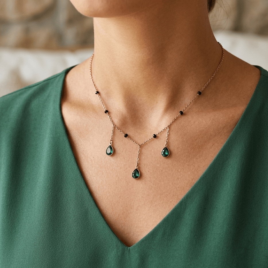 Necklace with green gemstones worn by a person in a green top.