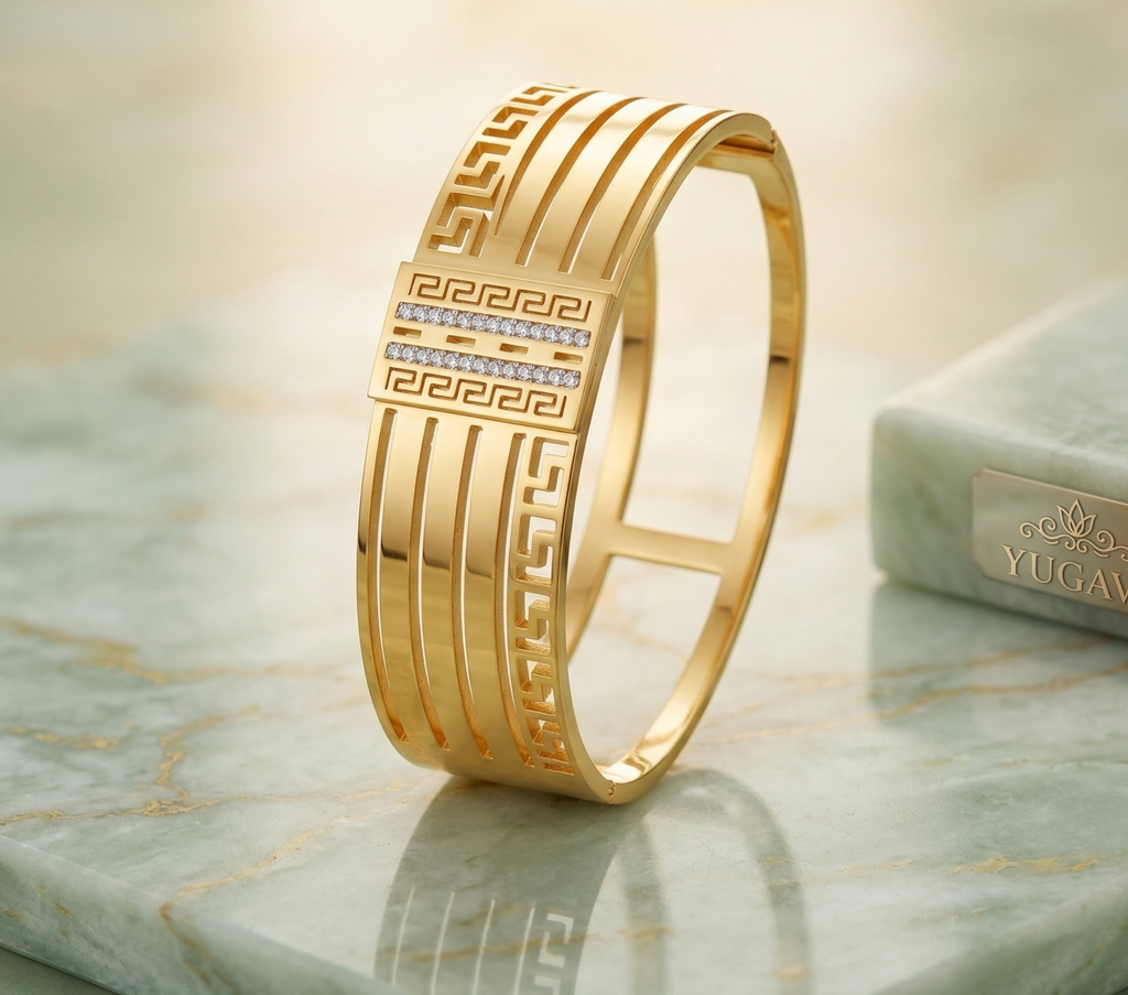 Gold bracelet with intricate design on a marble surface, featuring the YUGAVE brand.