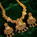 Yugavi Mayuri antique gold peacock earring front and back view — five-petal flower stud, triangular engraved body with kundan stone, scrolling peacock tail motifs, ruby and emerald teardrop fringe with ghungroo drops — House of Yugavi