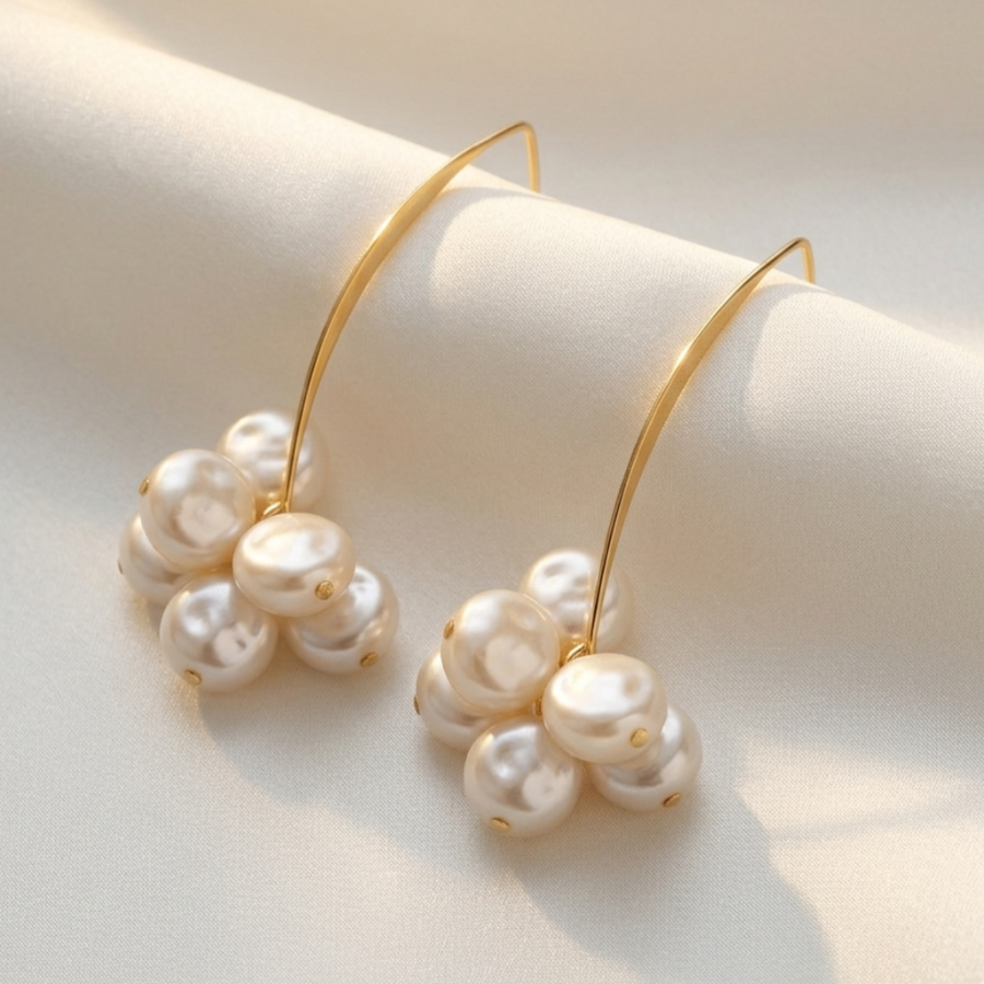 Gold hoop earrings with pearls on a beige background