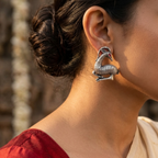 Woman wearing a silver earring with a blurred background