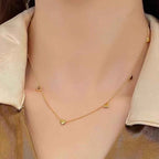 Yugavi Saisha gold heart chain necklace flat lay — full length showing approximately nine to ten puffy 3D gold hearts distributed evenly along a fine cable chain with lobster clasp, displayed on white background