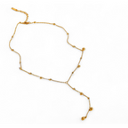 Yugavi Shyla gold Y-lariat necklace flat lay — fine satellite ball station chain with evenly spaced polished gold ball beads forming the main loop, Y-drop tail with matching satellite balls ending in two graduated gold ball drops, lobster clasp with extension, displayed on white background