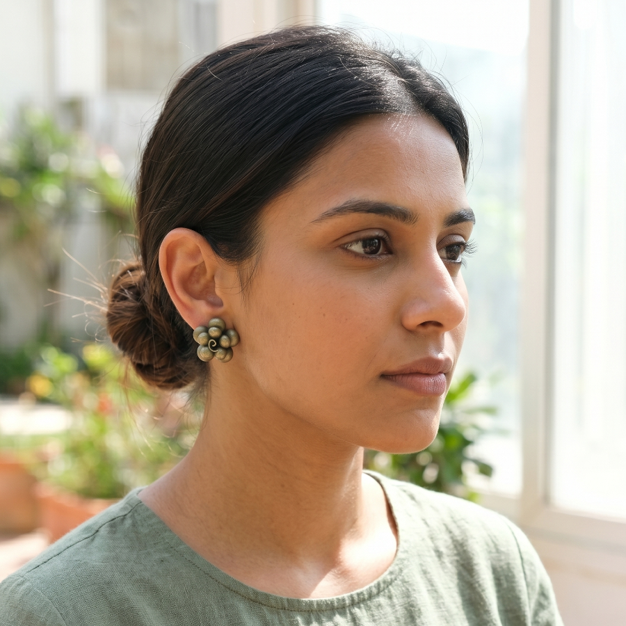 Woman wearing earrings with a blurred outdoor background