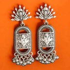 Close-up of silver ethnic earrings with lotus carving