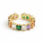 Gold hoop earrings with multicolored gemstones on a white background