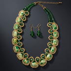A gold and green beaded statement necklace with matching drop earrings, displayed on a dark gray background.