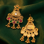 ugavi Mayuri antique gold peacock necklace and earring set flat lay — short haar with gold dori closure, double peacock pendant with ruby and emerald teardrop fringe, matching fan-shaped earrings 